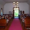 wooden pews, aisle runner, double door entry down center aisle