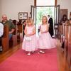 Flower girls in pink dresses spread the petals